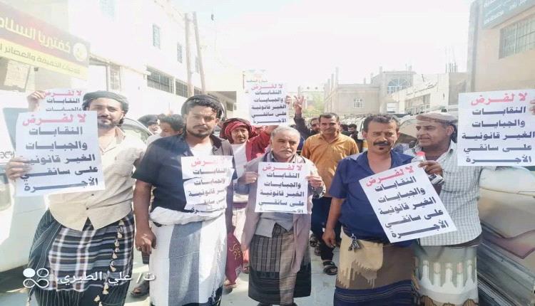 سائقو النقل البري ينفذون مظاهرة احتجاجية في لبعوس يافع رفضاً للجبايات غير القانونية